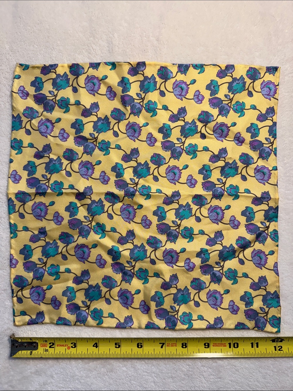 Unbranded floral patterned purple and yellow silk pocket square. 12” x 12”.